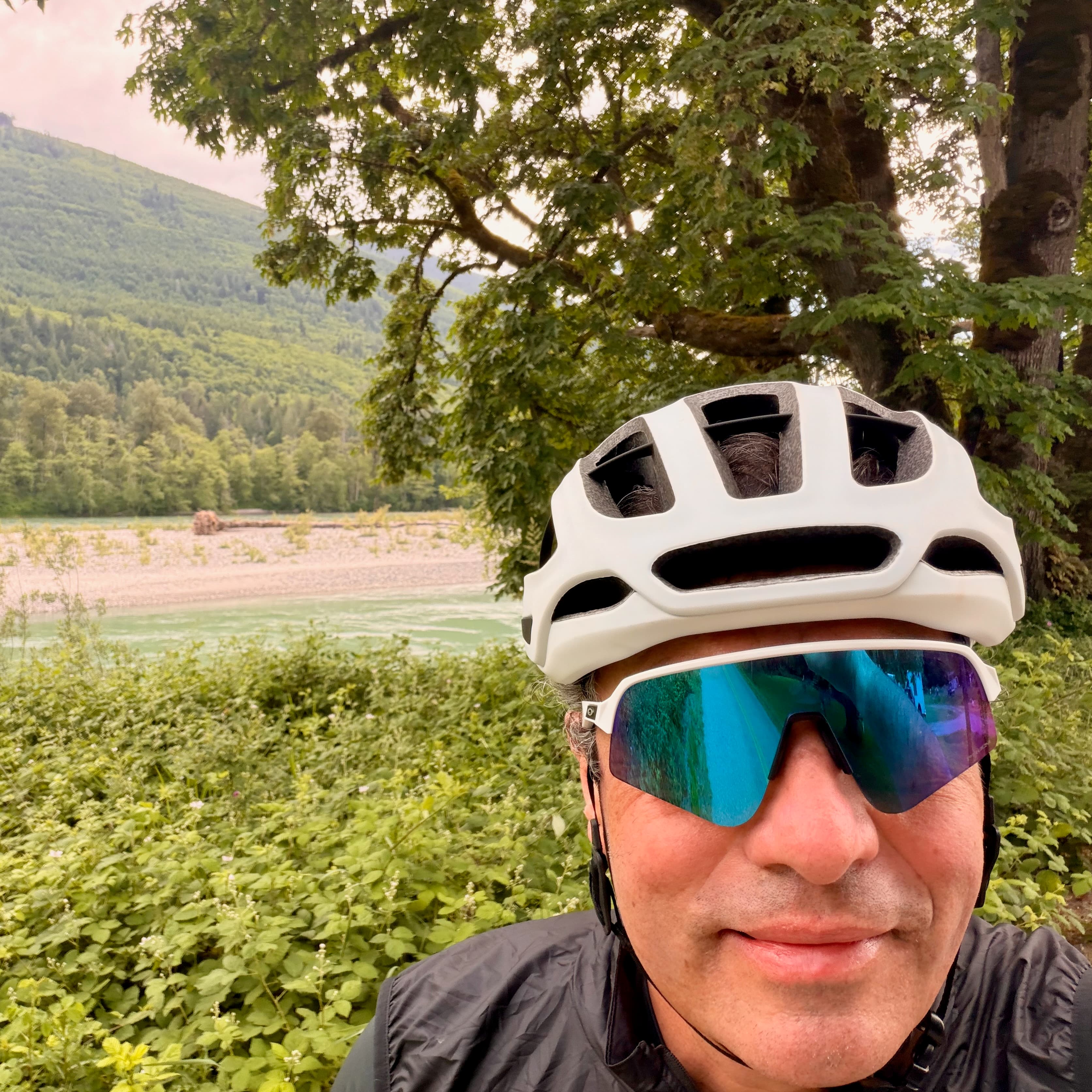 Dimitri Blondeel on a Pacific Northwest ride — river bar in the background, helmet on, mirrored lenses.